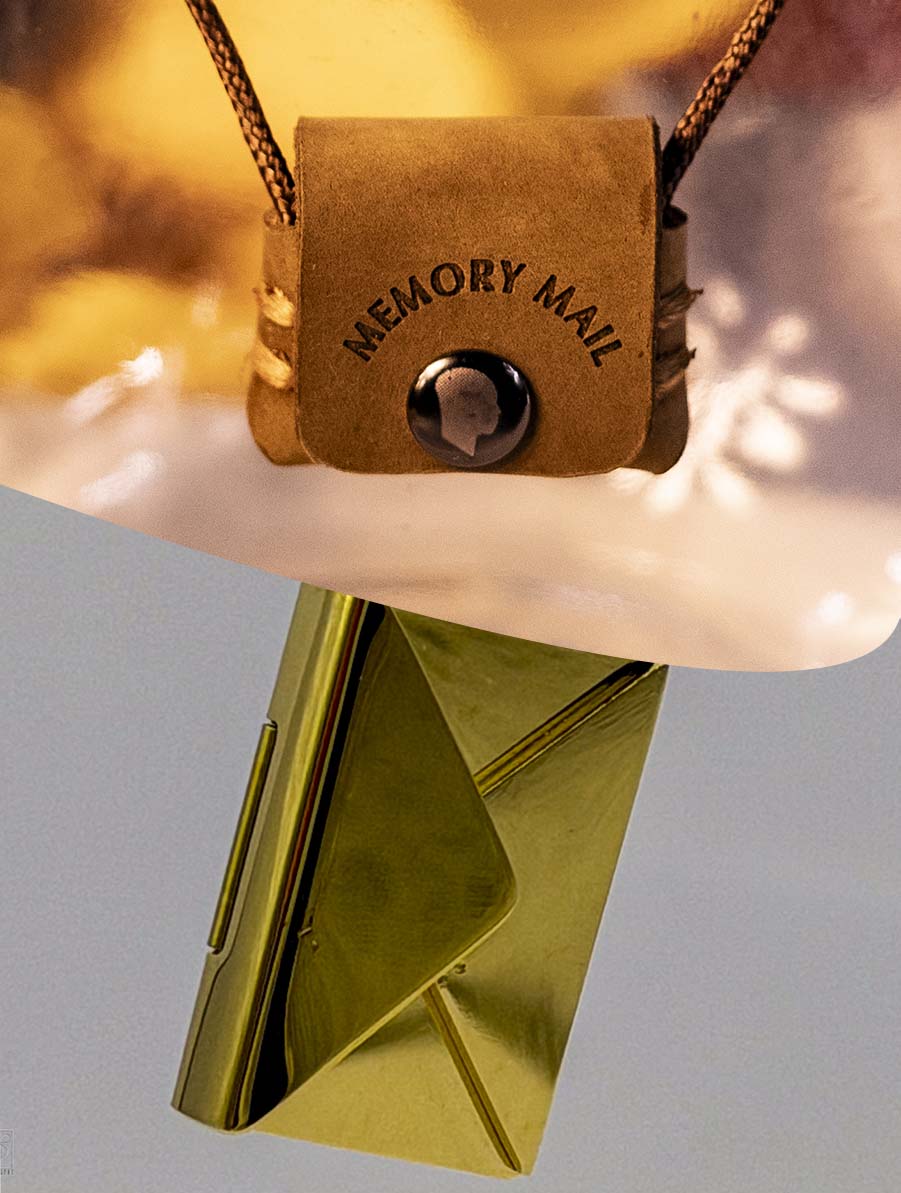 Brown leather pouch necklace with 'Memory Mail' branding on a light gray background with gold stainless steel envelope that can be engraved