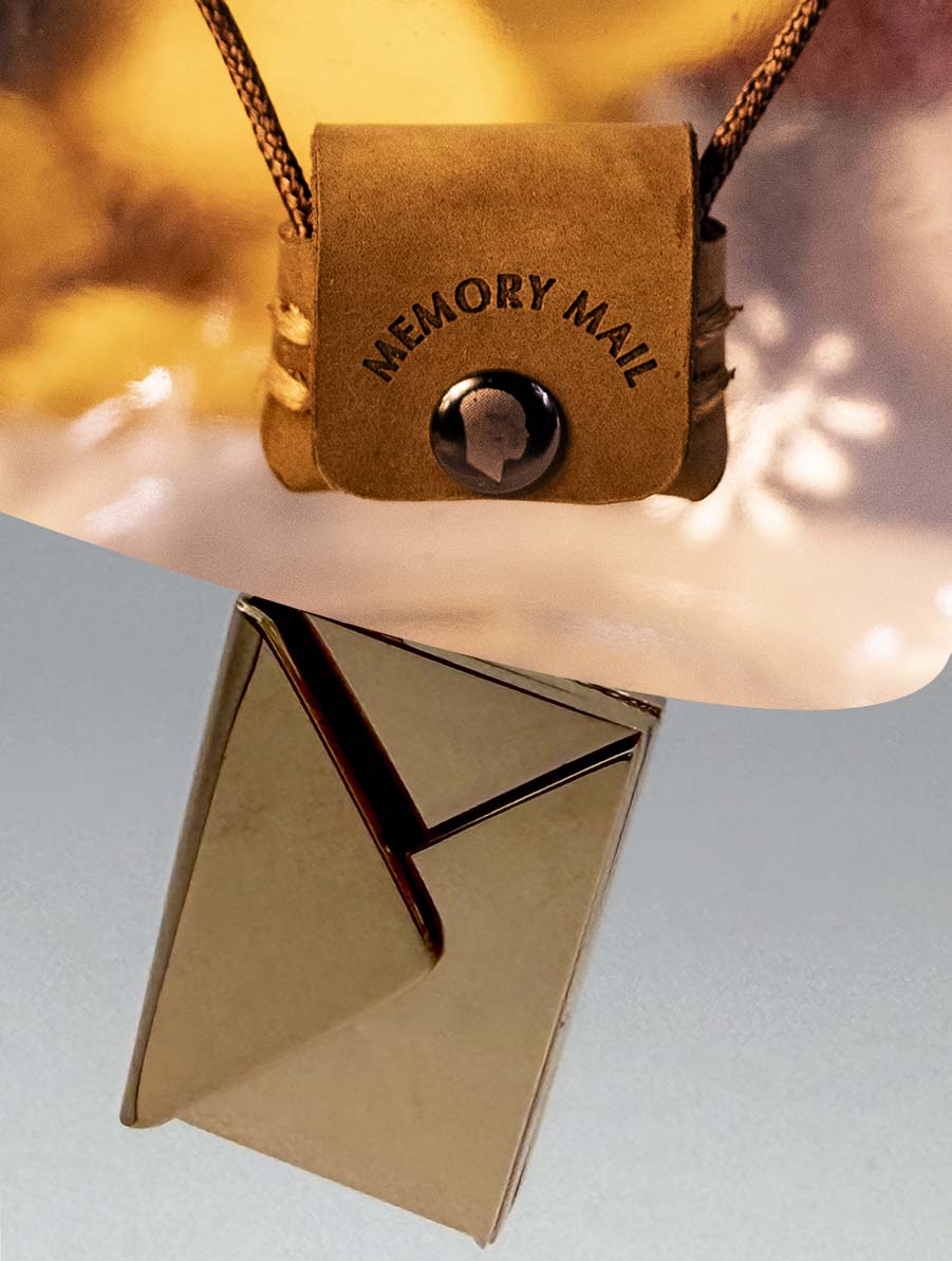 Small brown leather pouch with 'MEMORY MAIL' embossed on it, as well as a zoomed in picture of a rose gold stainless steel envelope which can be engraved. 