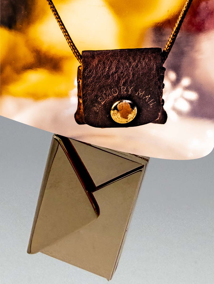 Necklace with a brown leather pendant featuring 'Memory Mail' branding, against a blurred background.