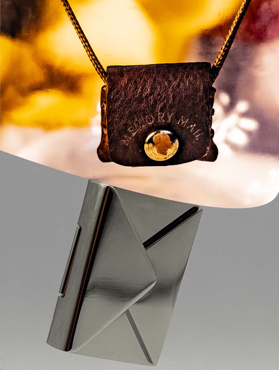 Brown leather pouch with gold clasp on a stand against a blurred background and a stainless steel colored engravable envelope. 